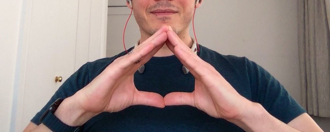 Chris joining his thumbs and forefingers into a triangle, the delta: a request to change topic.